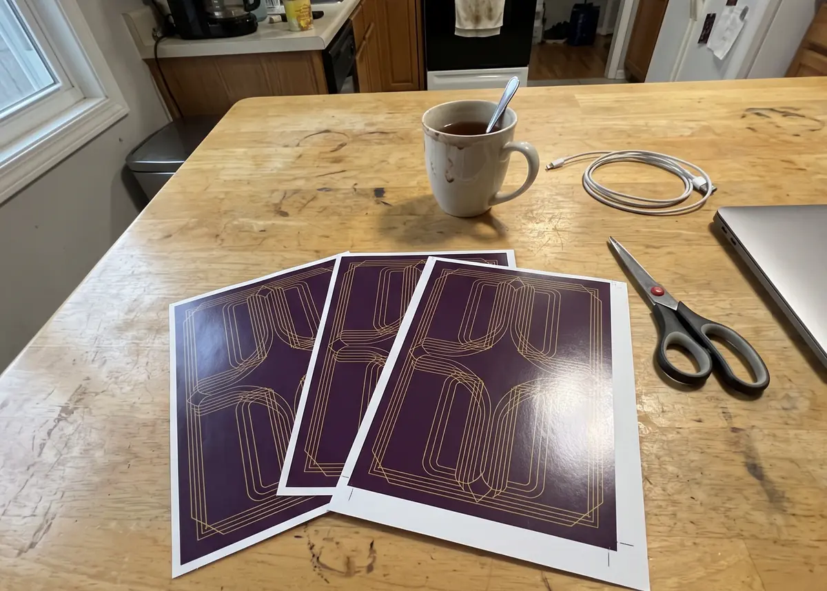 Sheet of the deck freshly printed at home, face down on a kitchen table with a mug and scissors